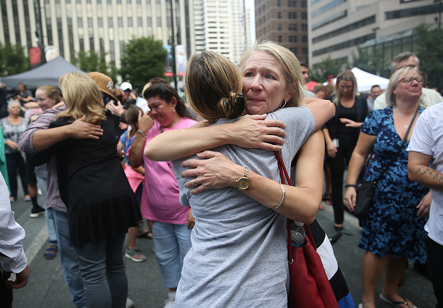 Jill Meyer gives a hug on Fountain Square during a memorial service hosted by Fifth Third, United Way, Downtown Cincinnati Inc. on Friday, September 7, 2018.  The city hosted a time for memorial and reflection following the shooting at Fifth Third Center on Fountain Square on Thursday.