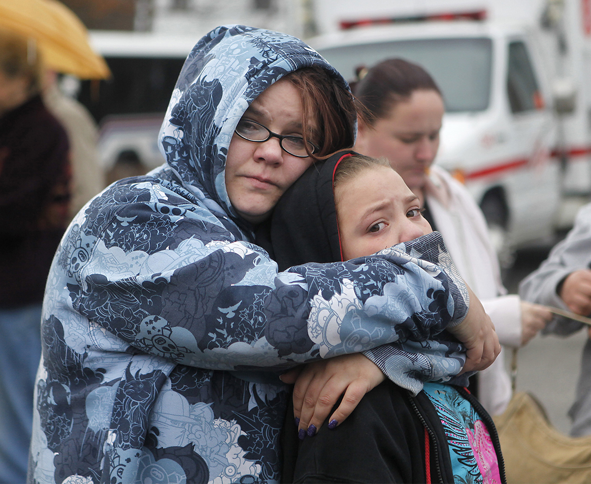 FATALFIRE  MARCH 4, 2011  Amy Helton hugs her daughter Jennifer Ross, 10, as they look back at the remains of their apartment after a fatal fire at the Roxbury Apartments in Mt. Washington on Friday, March 4, 2011.  Darlene Harlow died in the fire, and many residences are displaced. Helton was there at the time (her three kids were in school) and she says she was lucky to get out.  All of her stuff was destroyed in the fire.  The Enquirer/Leigh Taylor