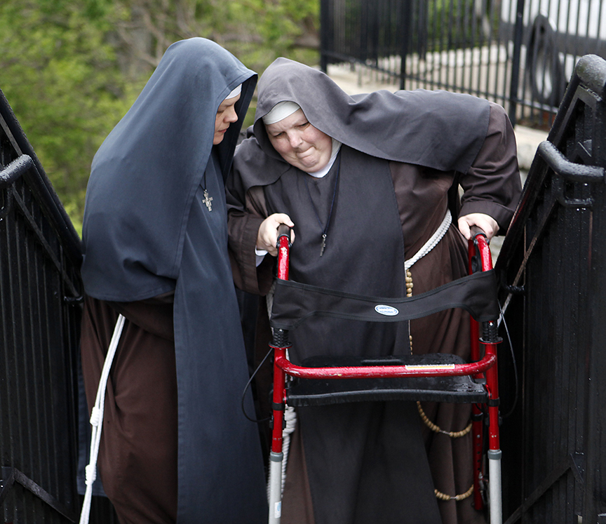 PRAYINGSTEPS   One nun helps another nun make it up the final steps leading to the Holy Cross-Immaculata church in Mt. Adams on Friday, April 22, 2011.  The nuns are praying together as they walk the 96 steps to the church.  The Enquirer/Leigh Taylor